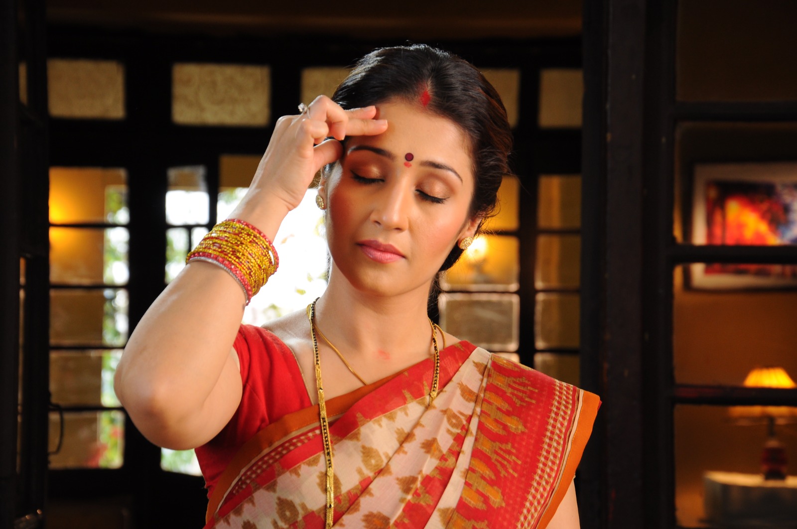 Woman resting her fingers against her forehead with her eyes closed